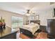 Well-lit main bedroom with wood floors, fan, and window with a view at 608 Grand Canal Dr, Poinciana, FL 34759