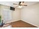 Bright bedroom featuring sleek wood floors, a modern ceiling fan, and a large window offering plenty of natural light at 608 Grand Canal Dr, Poinciana, FL 34759