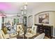 Open-concept living and dining area with a glass dining table, modern lighting, and stylish decor at 608 Grand Canal Dr, Poinciana, FL 34759