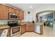 Kitchen with stainless steel appliances, granite countertop, tile backsplash, and modern sink fixtures at 608 Grand Canal Dr, Poinciana, FL 34759
