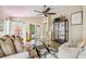 Cozy living room featuring a plush sofa, glass coffee table, and an open view of the backyard at 608 Grand Canal Dr, Poinciana, FL 34759
