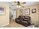 Relaxing living room with a cozy leather sofa, neutral walls, tile flooring, and access to another room at 608 Grand Canal Dr, Poinciana, FL 34759