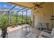 Relaxing patio area, perfect for outdoor seating and enjoying the lush greenery in a screened-in enclosure at 608 Grand Canal Dr, Poinciana, FL 34759