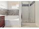 Bright bathroom featuring a glass-enclosed shower and a soaking tub with stone backsplash at 7013 Beargrass Rd, Harmony, FL 34773