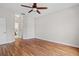 Spacious bedroom with hardwood floors, a ceiling fan, and doorway to ensuite bathroom at 7013 Beargrass Rd, Harmony, FL 34773