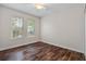 Bright and airy bedroom with wood floors and lots of natural light from two windows at 7013 Beargrass Rd, Harmony, FL 34773