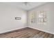 Clean, bright bedroom with wood floors, two windows, and neutral paint at 7013 Beargrass Rd, Harmony, FL 34773