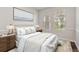 Serene bedroom with neutral tones, featuring a large bed, bedside tables, and natural light from two windows at 7013 Beargrass Rd, Harmony, FL 34773