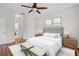 Comfortable bedroom featuring a padded headboard, two wooden bedside tables, and bench at the foot of the bed at 7013 Beargrass Rd, Harmony, FL 34773