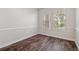 Cozy bedroom with wood floors, light walls, and natural light from two windows at 7013 Beargrass Rd, Harmony, FL 34773