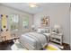 Charming bedroom featuring twin windows, a vibrant geometric rug, and a quirky surfboard as decor at 7013 Beargrass Rd, Harmony, FL 34773