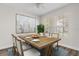Bright dining room featuring a rustic table set for six, large modern artwork, and abundant natural light at 7013 Beargrass Rd, Harmony, FL 34773