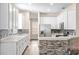 Modern kitchen featuring white cabinets, stainless steel appliances, and stylish stone backsplash at 7013 Beargrass Rd, Harmony, FL 34773