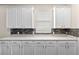 Spacious kitchen with white cabinetry, sleek countertops, and a stone backsplash under the window at 7013 Beargrass Rd, Harmony, FL 34773