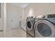 Bright laundry room with modern washer and dryer, plus counter and cabinet space at 7013 Beargrass Rd, Harmony, FL 34773