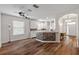Open-concept living area featuring wood floors and views into the kitchen and entryway at 7013 Beargrass Rd, Harmony, FL 34773