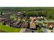 An aerial shot showcases a peaceful neighborhood, featuring neatly arranged houses, green lawns, and mature trees at 803 Shady Canyon Way, Kissimmee, FL 34759