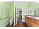 Bathroom featuring green walls, hardwood floors, a toilet, a sink, and a glass shower at 803 Shady Canyon Way, Kissimmee, FL 34759