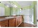 Bathroom with a glass shower, double sinks, and a large mirror with vanity lighting at 803 Shady Canyon Way, Kissimmee, FL 34759