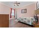 Comfortable bedroom with a pink accent wall, hardwood floors, and a window with blinds at 803 Shady Canyon Way, Kissimmee, FL 34759