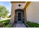 Inviting front entrance with a screened door, landscaped with lush greenery, and a charming brick walkway at 803 Shady Canyon Way, Kissimmee, FL 34759