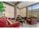 Cozy sunroom bathed in natural light features comfortable seating and travertine flooring at 803 Shady Canyon Way, Kissimmee, FL 34759