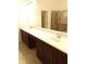 Bathroom featuring a double vanity with white countertops and a tiled shower at 8607 Crescendo Ave, Windermere, FL 34786