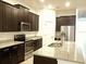 A kitchen showcasing stainless steel appliances, dark cabinetry, and granite countertops at 8607 Crescendo Ave, Windermere, FL 34786