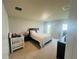Bright bedroom with a king bed, a crib, carpet flooring and white trim at 1190 Lexington Lane, Haines City, FL 33844