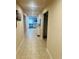 A hallway with tile flooring leading to an open-concept living area at 1190 Lexington Lane, Haines City, FL 33844