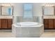 Bright bathroom featuring a soaking tub, dual vanities, and decorative mirrors at 1211 Terralago Way, Kissimmee, FL 34746