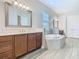 Bright bathroom featuring a large vanity, soaking tub, and tile floors at 1211 Terralago Way, Kissimmee, FL 34746