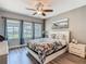 Bright bedroom featuring a decorative ceiling fan, hardwood floors, and three windows with nice trim at 1211 Terralago Way, Kissimmee, FL 34746