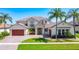 Stunning two-story home with lush landscaping, a paver driveway, and a barrel tile roof at 1211 Terralago Way, Kissimmee, FL 34746
