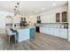 A spacious kitchen featuring a large island with marble countertop, pendant lighting, and stainless steel appliances at 1211 Terralago Way, Kissimmee, FL 34746