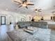 A spacious living room with a large gray sectional sofa and large screen TV, perfect for entertaining guests at 1211 Terralago Way, Kissimmee, FL 34746