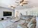 A spacious living room with a large gray sectional sofa and large screen TV, perfect for entertaining guests at 1211 Terralago Way, Kissimmee, FL 34746
