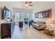 Home office with hardwood floors, ceiling fan, large windows, and a modern couch at 1211 Terralago Way, Kissimmee, FL 34746