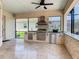 Outdoor kitchen featuring stone accents, stainless steel appliances, and a built-in grill at 1211 Terralago Way, Kissimmee, FL 34746