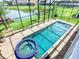 Aerial view of private screened pool and jacuzzi overlooking lush landscaping and the lake at 1211 Terralago Way, Kissimmee, FL 34746
