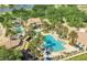 Aerial view of a community pool area with palm trees, a clubhouse and lounge chairs at 1211 Terralago Way, Kissimmee, FL 34746