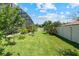 Lush backyard with green grass, tropical landscaping, and privacy fence at 12649 Dallington Ter, Winter Garden, FL 34787