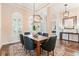 Bright dining area featuring a modern chandelier, wood floors, and plantation shutters at 12649 Dallington Ter, Winter Garden, FL 34787