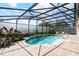 Relaxing screened-in pool with a spa is surrounded by lush landscaping and a brick patio at 12649 Dallington Ter, Winter Garden, FL 34787
