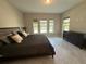 Inviting bedroom featuring tile floors, large windows, and a comfortable bed with accent pillows at 13065 Gabor Ave, Orlando, FL 32827