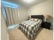 Cozy bedroom featuring a comfortable bed with a grey and white checkered pattern and two bedside lamps at 13065 Gabor Ave, Orlando, FL 32827