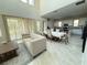 Open-concept living room and dining area with neutral color palette and lots of natural light at 13065 Gabor Ave, Orlando, FL 32827
