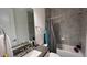 Modern bathroom featuring gray tiling, granite countertops, and a shower-tub combination at 13885 Arclid St, Orlando, FL 32832