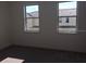 Bedroom with two windows and carpeted floor, showing a glimpse of the neighborhood at 13885 Arclid St, Orlando, FL 32832