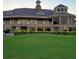 Beautiful clubhouse featuring stone accents, balconies, and a clock tower overlooking a pristine green lawn at 13885 Arclid St, Orlando, FL 32832